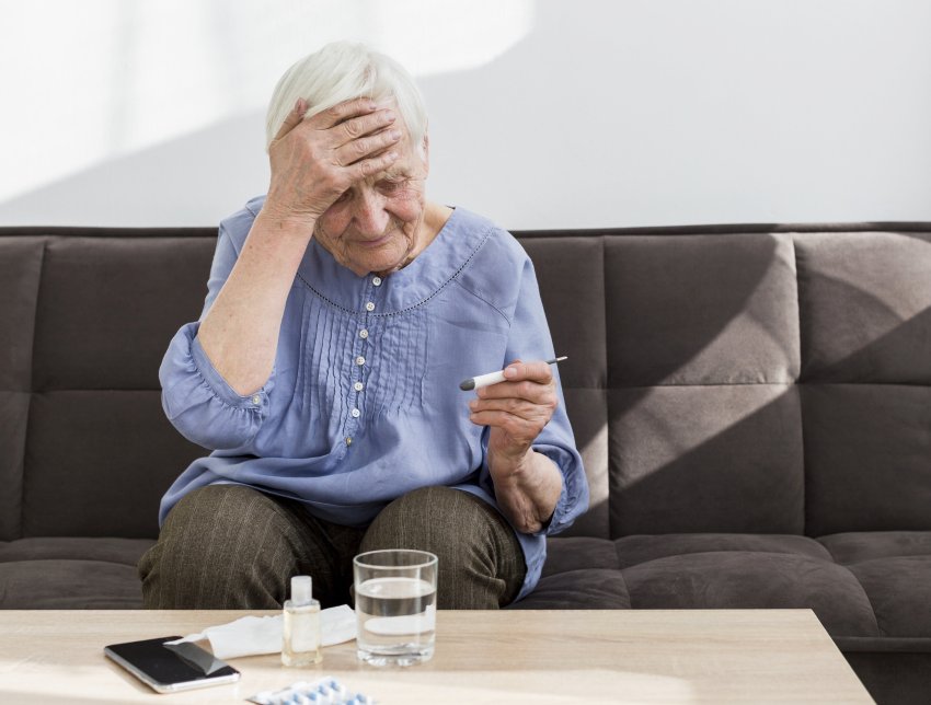 elder woman concerned with thermometer