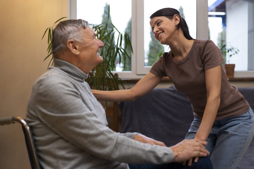 elderly person being taken care by female caretaker 