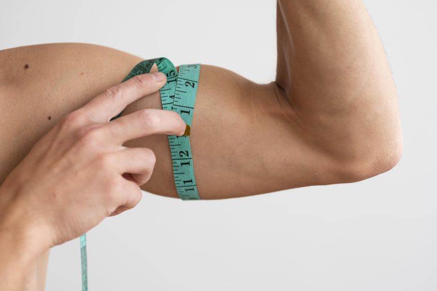 man measuring his bicep with tape