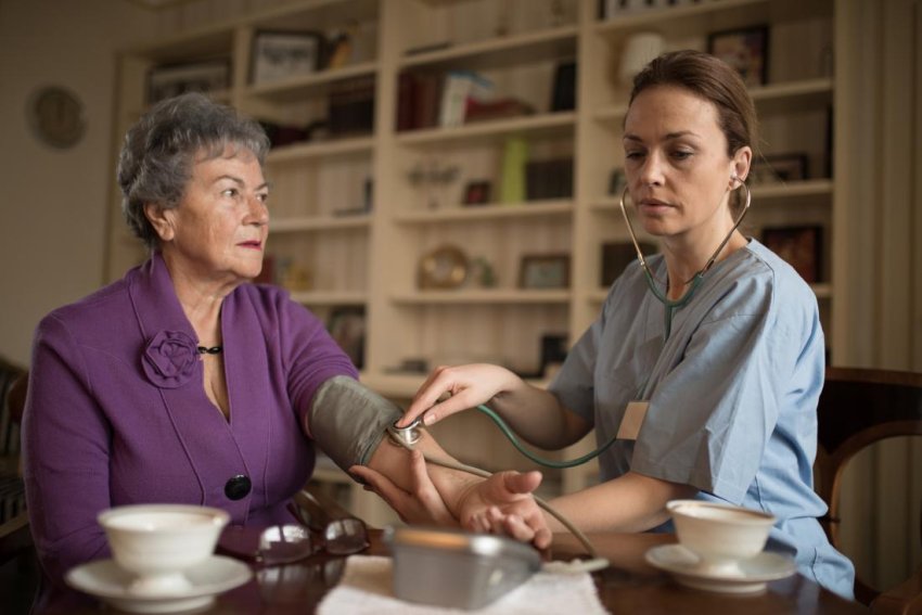 nurse checking patient blood pressure