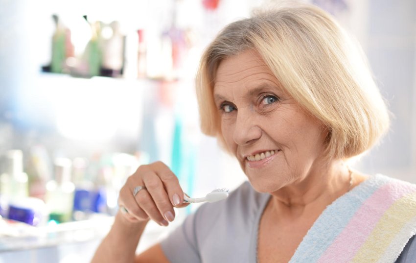 senior woman brushing her teeth